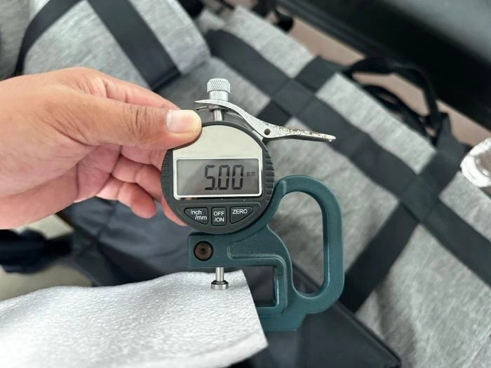 Thickness gauge measuring a foam sample during bag inspection