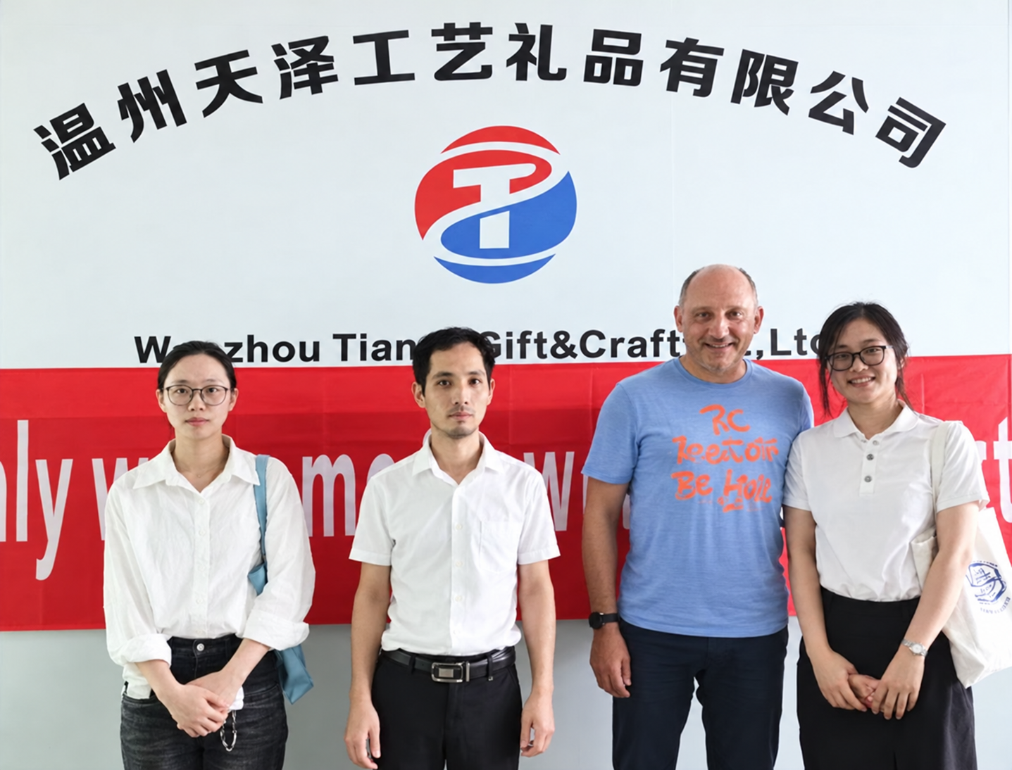 Tianze team with a customer in front of the company sign